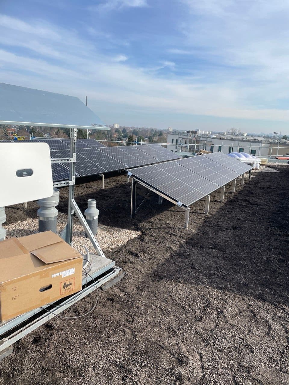 Wechselrichter-Station mit Huawei-Wechselrichter und fertig installierten Photovoltaik-Modulen im Hintergrund auf dem Dach der Rudower Straße.