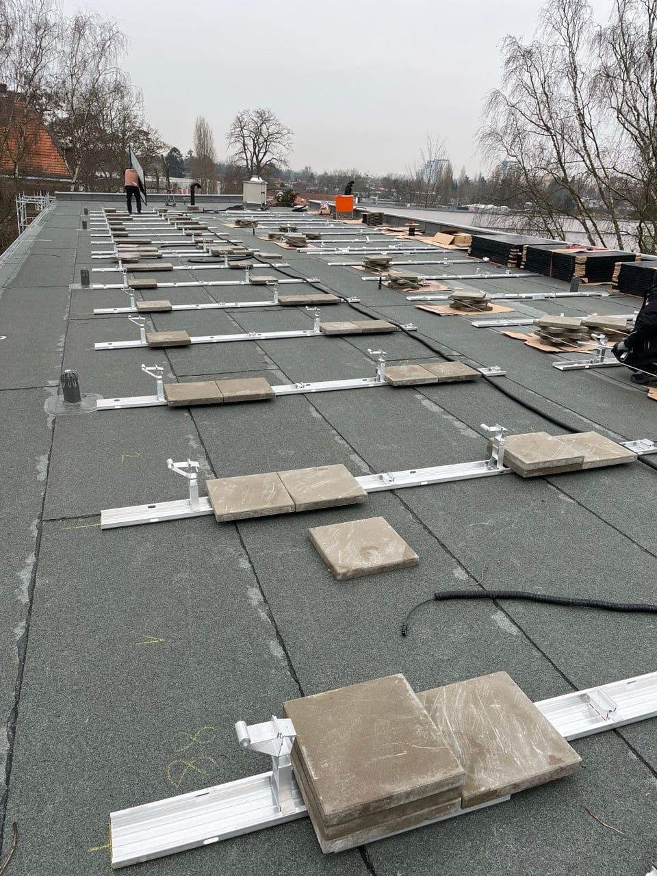 Hier zu sehen ist die Vorbereitung der Unterkonstruktion mittels Ballast. Die Unterkonstruktion wird nur durch Auflast befestigt, die Dachhaut wird nicht beschädigt. www.sundaysolar.de