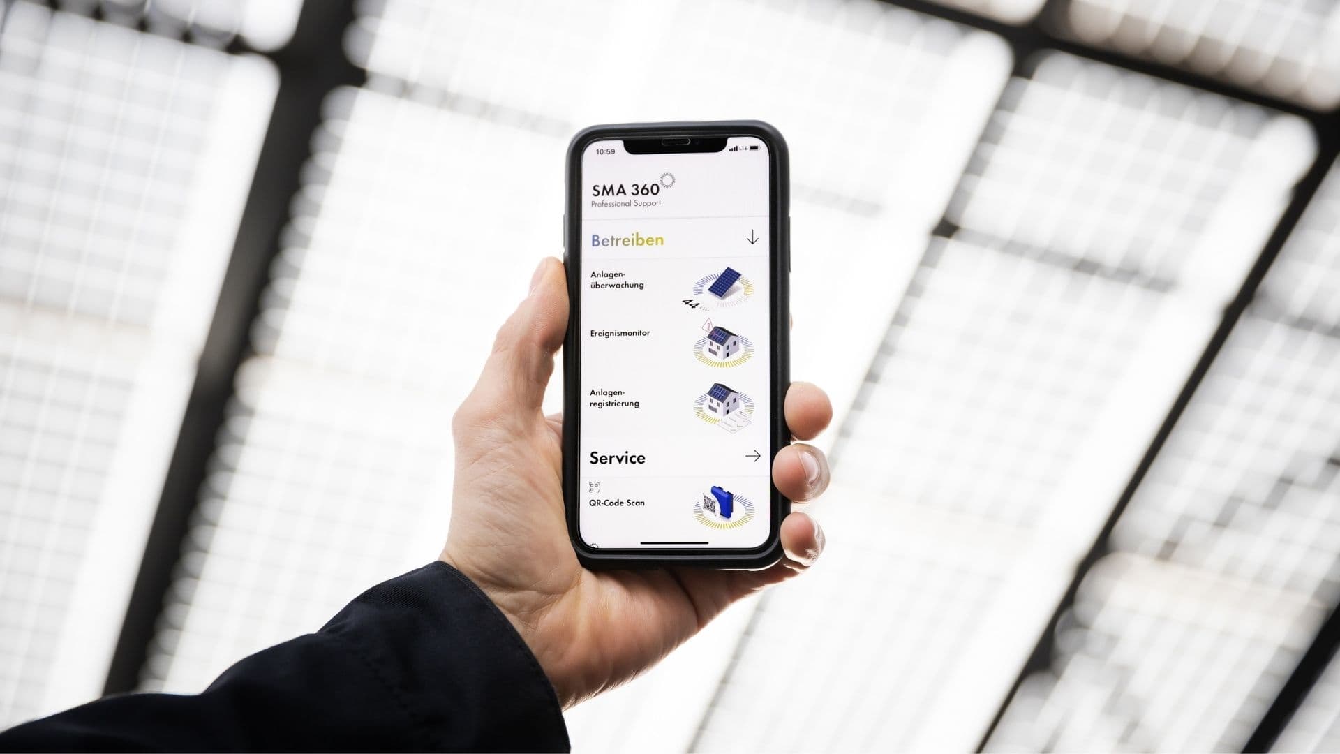Ein Hand hält ein Handy in die Luft. Auf dem Screen ist ein Energiemanagement-System zu sehen